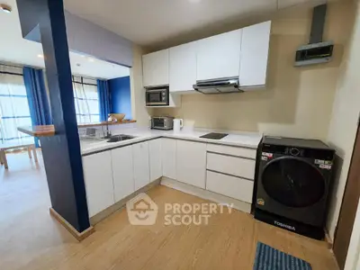 Modern kitchen with sleek white cabinets and integrated appliances in open layout