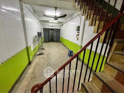 Spacious tiled interior with staircase and ceiling fans, ideal for versatile use.