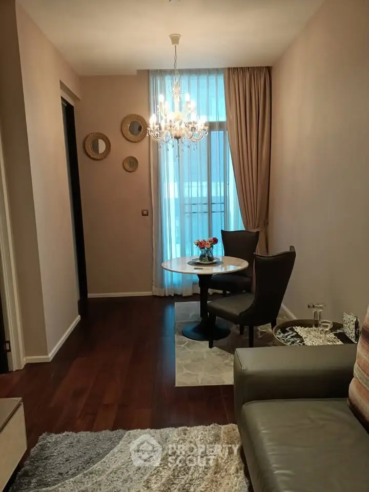 Elegant living room with chandelier and cozy seating area, perfect for relaxation and entertaining.
