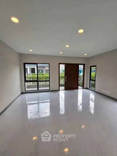 Spacious modern living room with large windows and elegant flooring