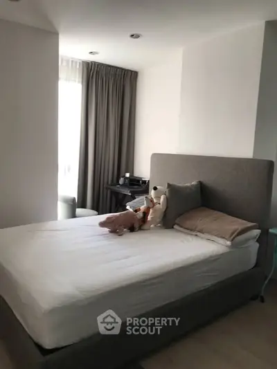 Cozy bedroom with plush bed and natural light, perfect for relaxation.