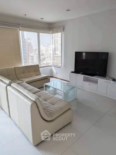Modern living room with sleek white furniture and city view, perfect for urban living.