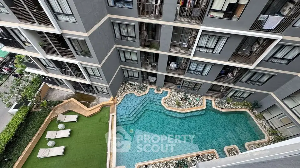 Modern apartment building with stylish pool and sun loungers in urban setting