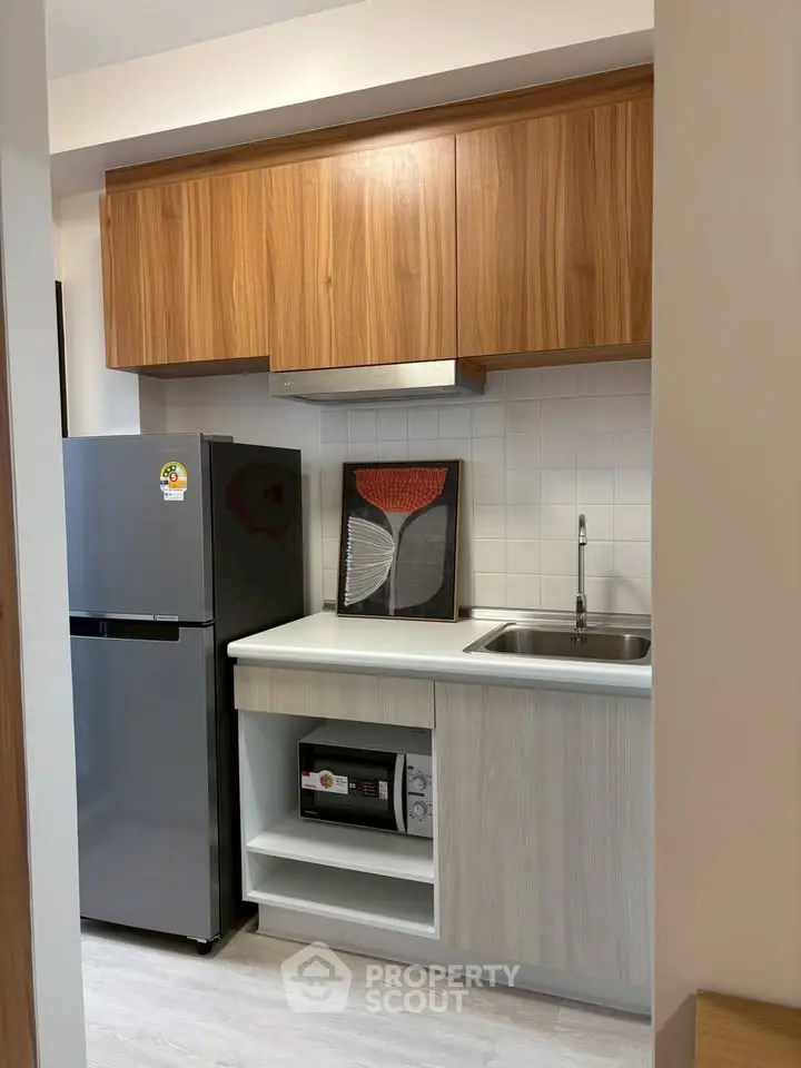Modern compact kitchen with sleek cabinetry and stainless steel appliances