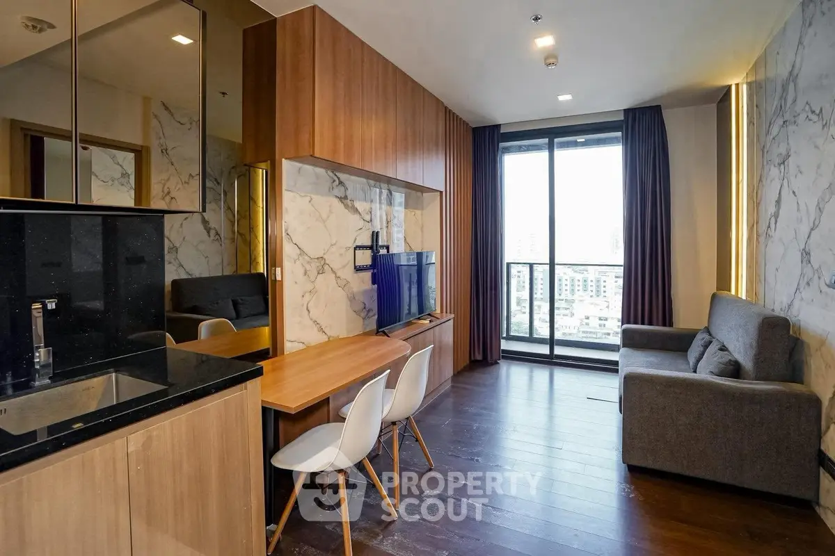 Modern living room with stylish decor, large window, and open kitchen layout in a high-rise apartment.