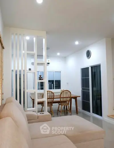 Modern living room with open dining area and cozy beige sofa