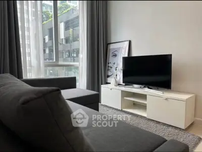 Modern living room with sleek furniture and large windows in urban apartment.