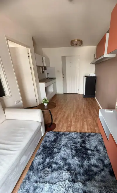 Modern living room with stylish decor and cozy ambiance, featuring sleek furniture and wooden flooring.