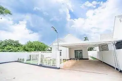 Spacious modern driveway with covered parking and lush greenery.