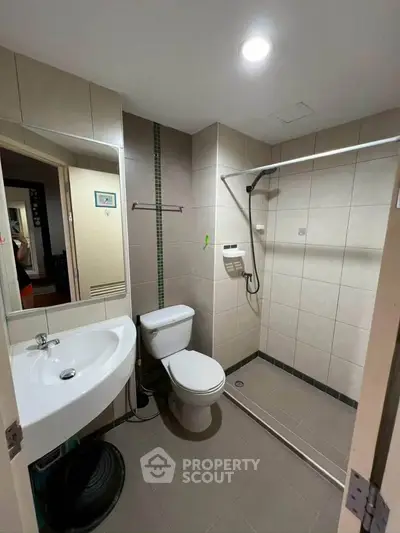 Modern bathroom with walk-in shower and sleek fixtures in a contemporary apartment.