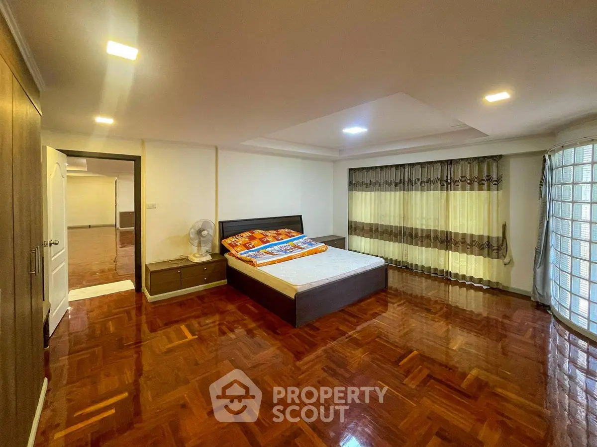 Spacious bedroom with wooden flooring and modern decor