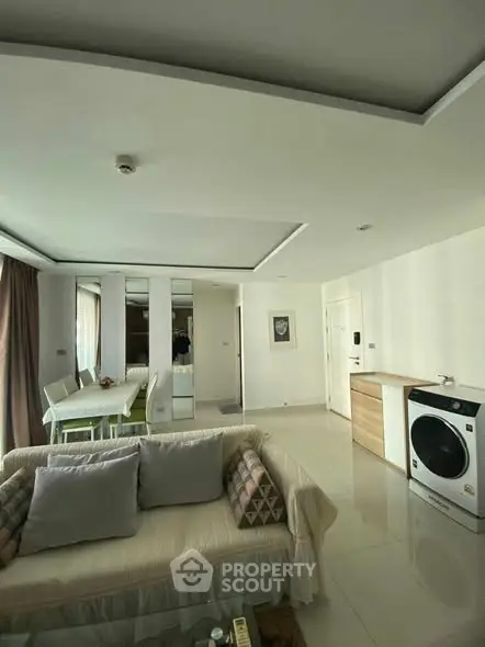 Modern living room with stylish decor and washing machine in open layout.