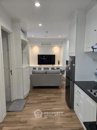 Modern open-plan kitchen and living room with sleek design and wooden flooring.