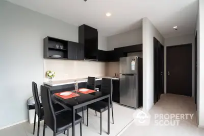 Modern kitchen with sleek black cabinets and dining area in stylish apartment