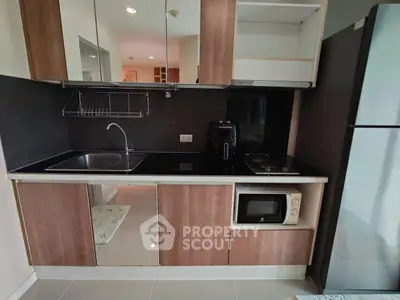 Modern kitchen with sleek cabinets, stainless steel sink, and built-in appliances in a stylish apartment.