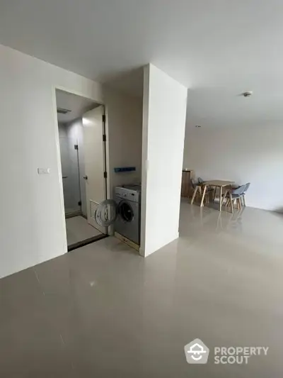 Modern apartment interior with washing machine and dining area