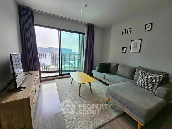 Modern living room with stylish furniture and city view balcony.