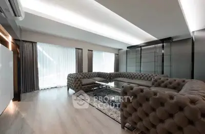 Luxurious modern living room with elegant tufted sofas and large windows