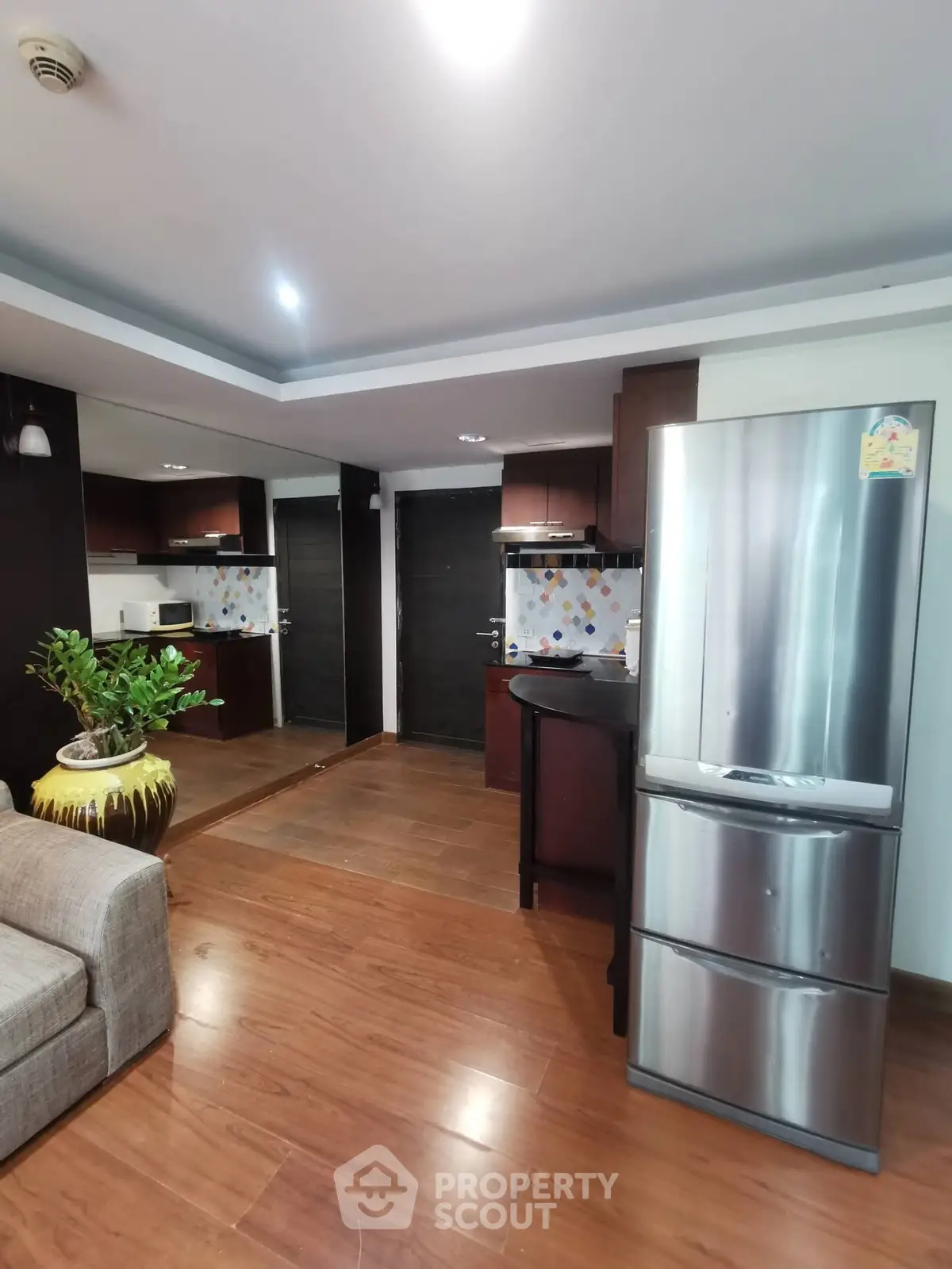 Modern kitchen with stainless steel fridge and stylish wooden flooring