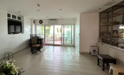 Spacious living room with large windows and balcony access, perfect for natural light and outdoor views.