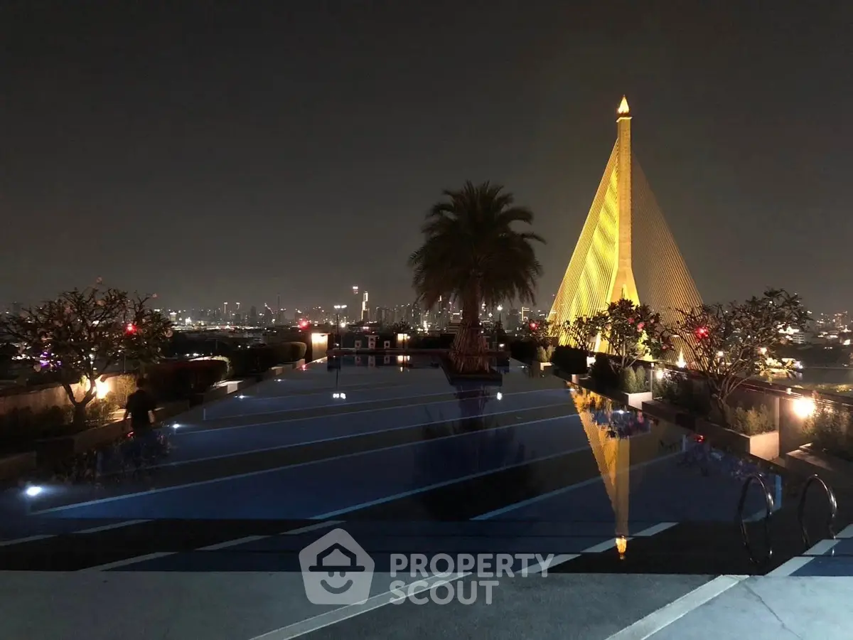 Stunning rooftop pool with city skyline view and iconic architecture at night.