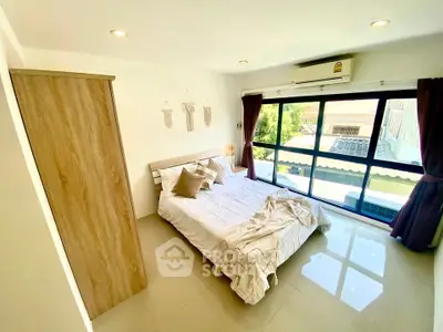 Bright and cozy bedroom with large window and modern decor