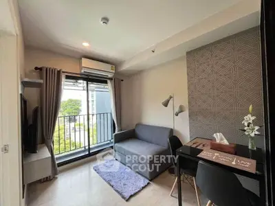 Modern living room with balcony, stylish decor, and natural light in urban apartment.