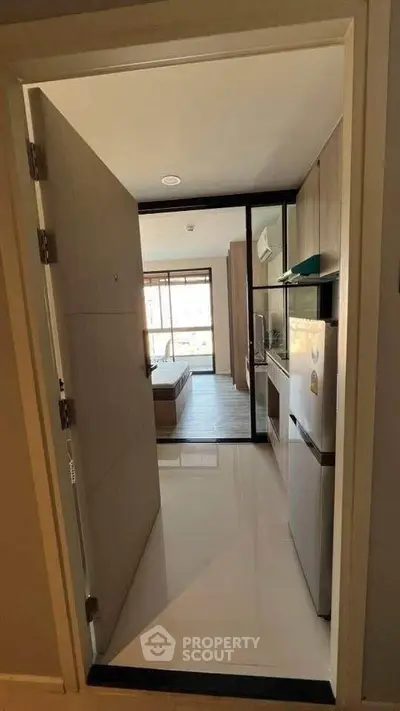 Modern apartment entrance leading to a cozy bedroom with sleek design.