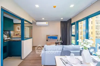 Modern living room with open kitchen and large windows in a stylish apartment.