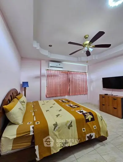 Cozy bedroom with ceiling fan, air conditioning, and TV, featuring a comfortable bed and stylish decor.