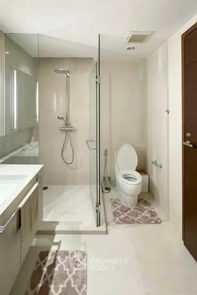 Modern bathroom with glass shower and sleek fixtures in a contemporary home.
