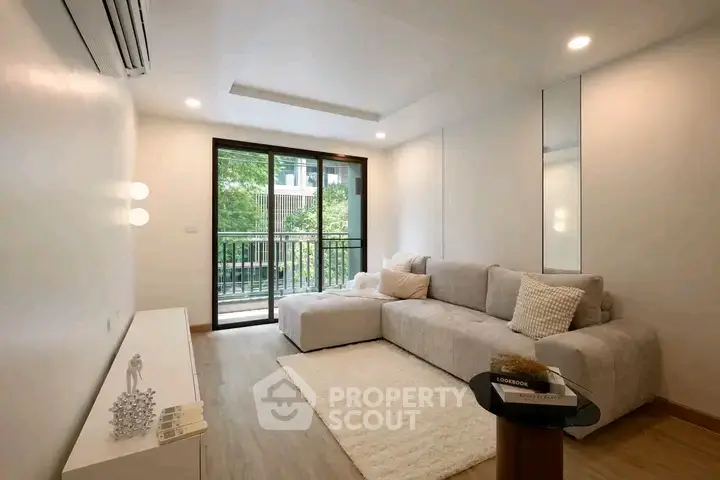 Modern living room with cozy sofa and balcony view in a stylish apartment.
