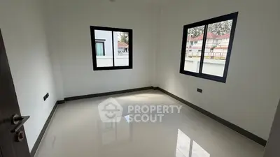 Spacious empty room with large windows and glossy tile flooring