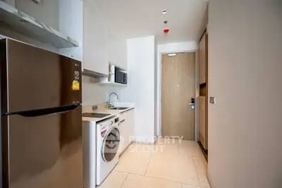 Modern kitchen with sleek appliances and stylish cabinetry in a contemporary apartment.