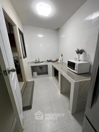 Modern kitchen with sleek countertops and built-in microwave, perfect for culinary enthusiasts.