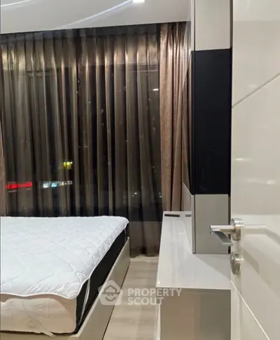 Modern bedroom with sleek design and floor-to-ceiling windows offering city views.