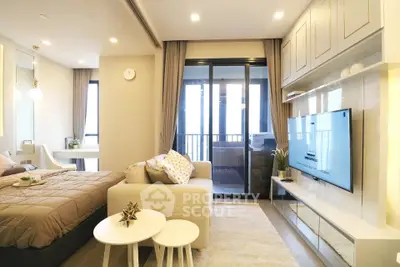 Modern studio apartment with cozy living area and stylish decor, featuring a large TV and balcony access.