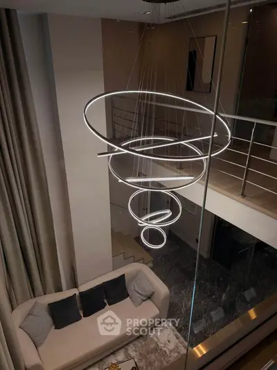 Luxurious modern living room with elegant spiral chandelier and plush sofa in a stylish duplex apartment.