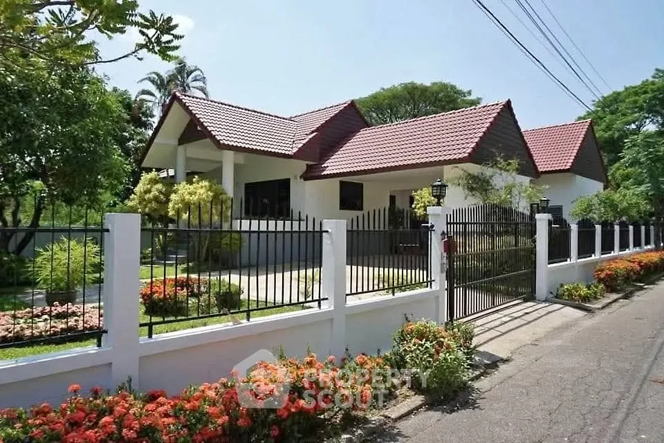 Charming single-story house with red-tiled roof and lush garden in a serene neighborhood.