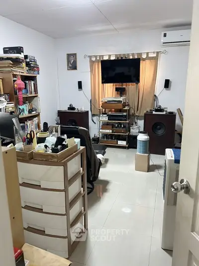 Cozy study room with bookshelves, sound system, and air conditioning.