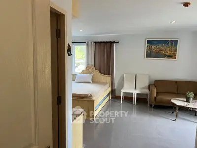Spacious bedroom with cozy seating area and natural light.