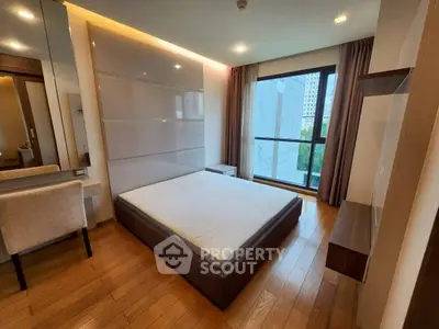 Modern bedroom with large window and wooden flooring in a high-rise apartment.