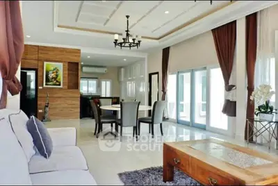Spacious living room with elegant decor and open layout, featuring large windows and stylish furniture.