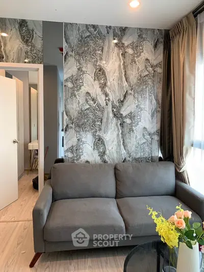 Modern living room with stylish marble accent wall and cozy gray sofa, perfect for urban living.