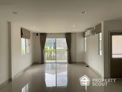 Spacious unfurnished living room with large windows and glossy tiled floors