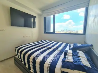 Modern bedroom with large window offering stunning city views and wall-mounted TV.