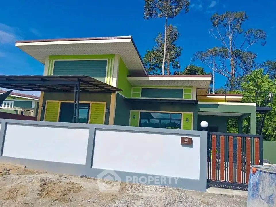 Modern single-story house with vibrant green accents and a sleek design, featuring a spacious front yard and secure gate.