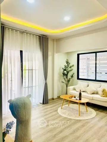 Modern living room with stylish decor and natural light, featuring a cozy sofa and elegant flooring.