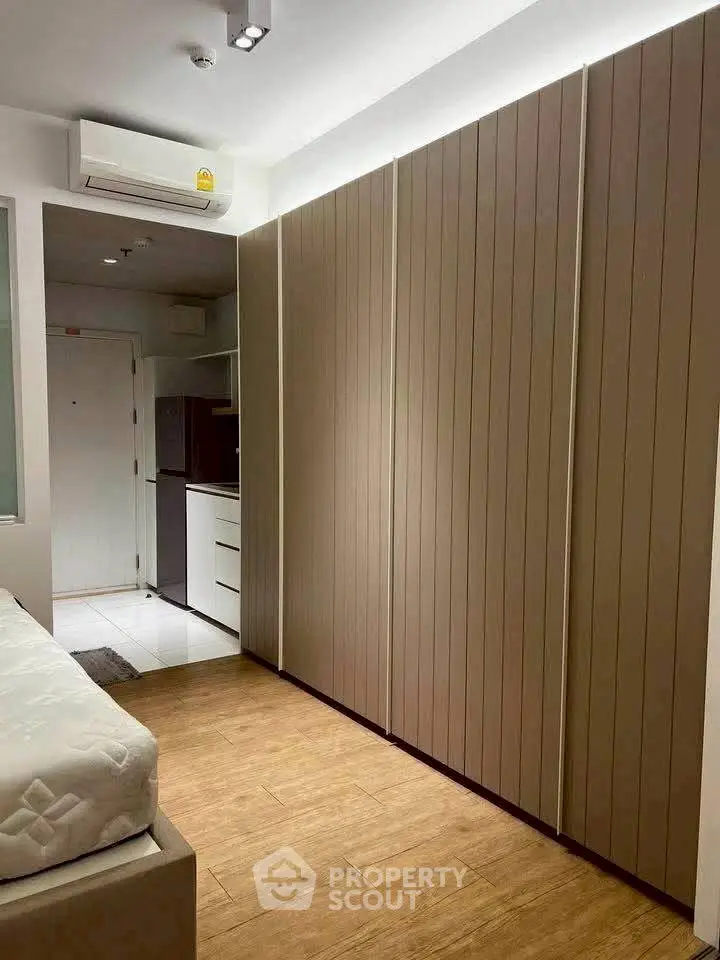 Modern bedroom with sleek wooden flooring and built-in wardrobe