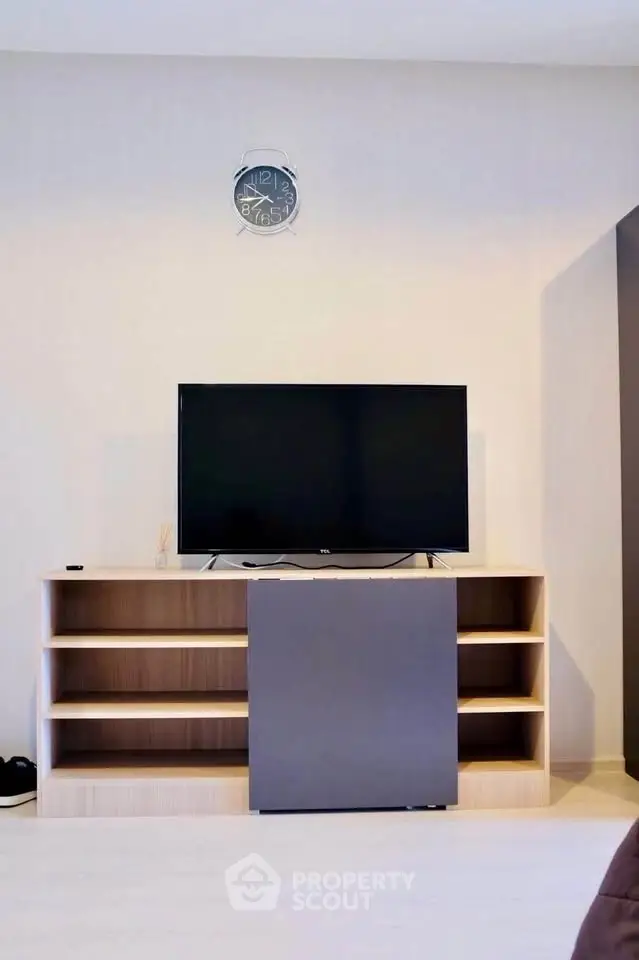 Modern living room with sleek TV stand and wall clock, perfect for contemporary homes.